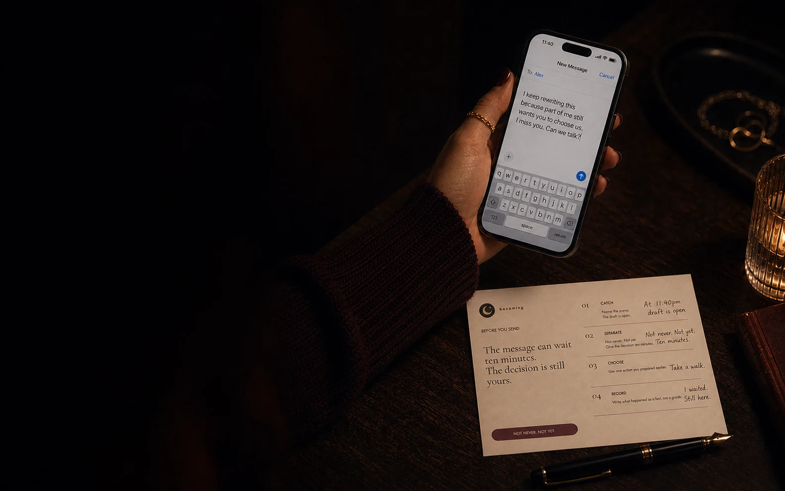 At night, a woman pauses over a readable unsent message while her completed Before You Send card rests beside the phone.